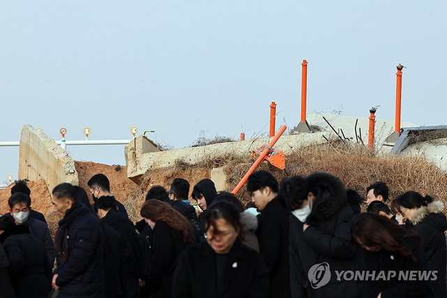 ‘12·29 제주항공 여객기 참사’ 1주기인 지난해 12월 29일 무안국제공항 참사 현장에서 유가족들이 콘크리트 둔덕을 둘러보고 있다. [무안=연합뉴스]