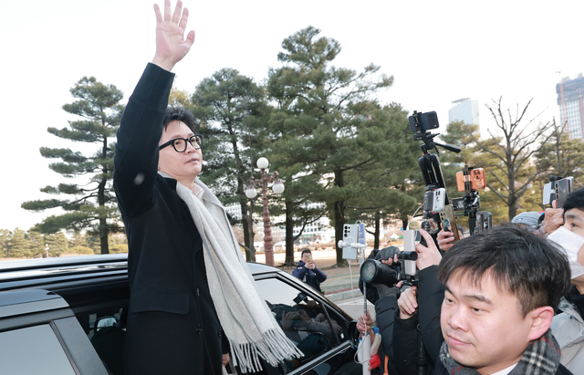 한동훈 전 국민의힘 대표가 14일 당 윤리위원회의 제명 결정 관련 기자회견을 마치고 국회의원회관을 잠시 방문한 뒤 차량에 탑승하며 지지자를 향해 손을 흔들고 있다. [연합뉴스]