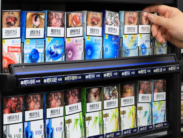 국민건강보험공단이 주요 담배 회사들을 상대로 제기한 533억원대 손해배상 청구 소송의 2심 선고 재판이 열린 15일 서울 한 편의점에서 점원이 진열된 담배를 들어 보이고 있다. [연합뉴스]
