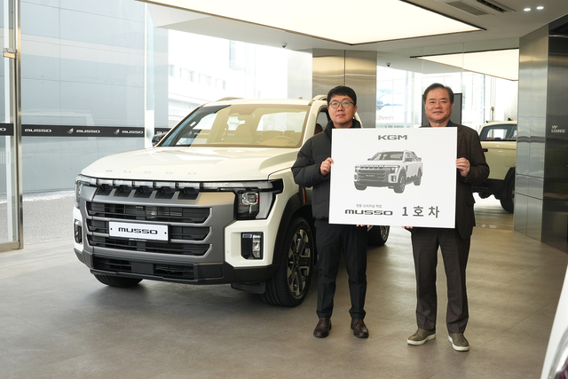 KGM 익스피리언스 센터 일산에서 지난 19일 열린 '무쏘 1호차 전달식'에서 1호차 주인공 이미남(왼쪽) 대표와 권교원 사업부문장이 기념촬영을 하고 있다. KGM 제공
