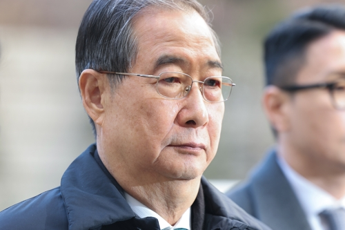 내란 우두머리 방조 혐의를 받는 한덕수 전 국무총리가 21일 서울중앙지법에서 열린 1심 선고 공판에 출석하기 위해 법정으로 향하고 있다.   [연합뉴스]