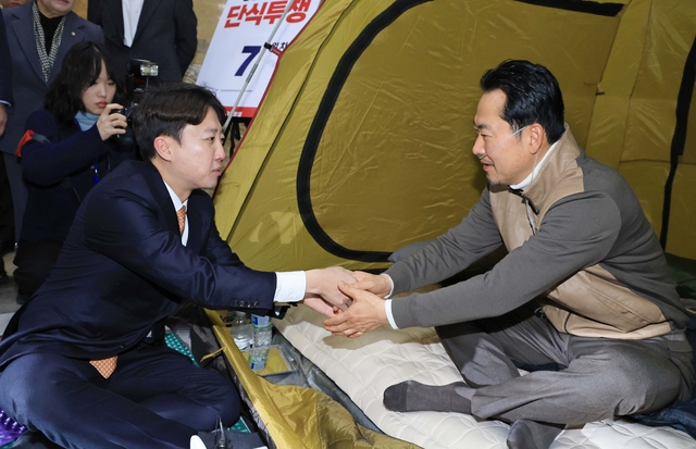 통일교·공천헌금 '쌍특검' 수용을 요구하며 단식 7일 차를 맞은 국민의힘 장동혁 대표가 21일 국회 로텐더홀 단식 농성장을 찾은 개혁신당 이준석 대표와 악수하고 있다.  [공동취재]
