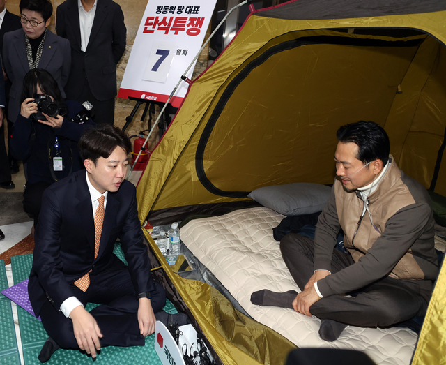 더불어민주당에 통일교·공천헌금 ‘쌍특검’ 수용을 요구하며 단식 7일차를 맞은 장동혁(오른쪽) 국민의힘 당대표가 21일 국회 본청 로텐더홀 단식 농성장을 찾은 이준석(왼쪽) 개혁신당 대표와 대화하고 있다.<공동취재·연합뉴스>