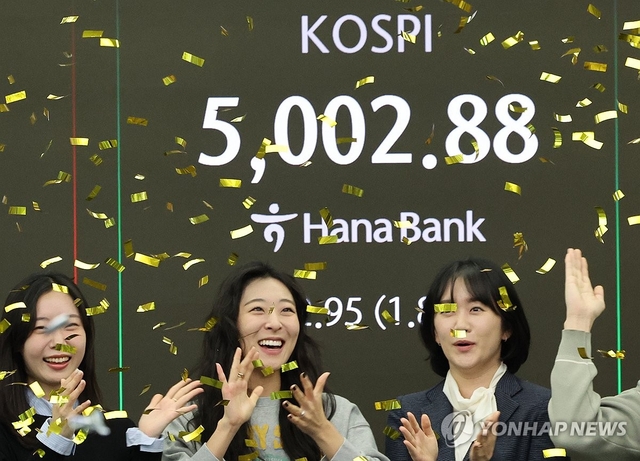 22일 오전 코스피 지수가 5000을 넘어서자 서울 중구 하나은행 딜링룸에서 외환 딜러들이 세리머니를 펼치고 있다. 연합뉴스