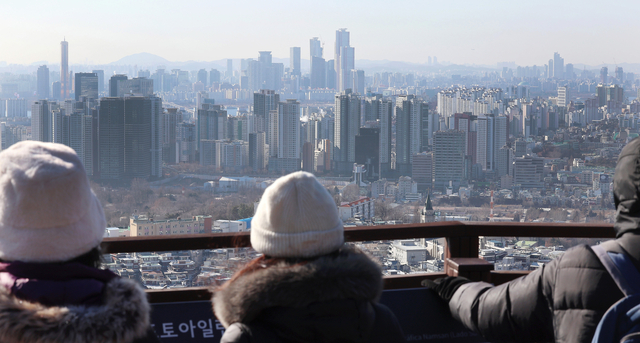 지난 8일 서울 남산 전망대를 찾은 시민들이 아파트가 빼곡한 풍경을 바라보고 있다. [연합뉴스]