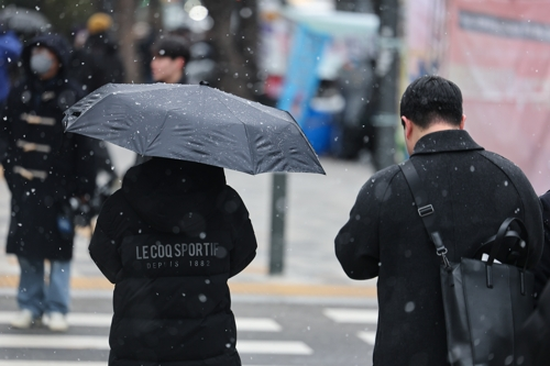 눈이 내린 지난 1월 12일 서울 중구 을지로입구역 인근에서 우산을 쓴 시민이 이동하고 있다. [연합뉴스]
