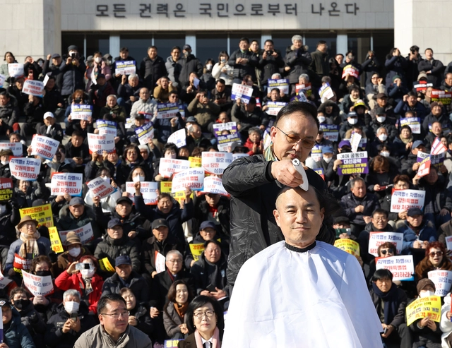 국민의힘 소속 김진태 강원특별자치도지사가 9일 국회 본청 앞에서 열린 강원특별법 ‘3차 개정안’ 통과 촉구를 위한 국회 상경 도민 결의대회에서 국회와 정치권에 항의하는 취지로 삭발 투쟁하고 있다.<연합뉴스 사진>
