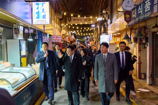 이재명 대통령이 9일 저녁 식사를 위해 방문한 서울 종로구 통인시장에서 상인들에게 인사하고 있다. 연합뉴스