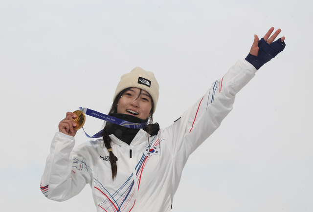 12일(현지시간) 이탈리아 리비뇨 스노파크에서 열린 2026 밀라노-코르티나담페초 동계올림픽 스노보드 여자 하프파이프 결승에서 우승한 최가온이 금메달을 손에 들고 미소를 짓고 있다. [리비뇨=연합뉴스]
