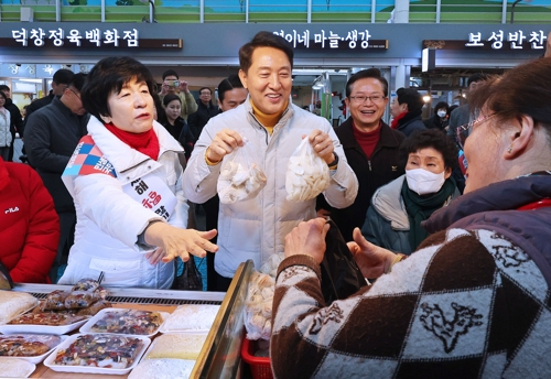 오세훈 서울시장이 설연휴 첫날인 14일 서울 영등포 전통시장을 찾아 만두와 떡을 구매하고 있다. [연합뉴스]