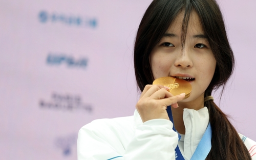 2026 밀라노ㆍ코르티나담페초 동계올림픽 스노보드 여자 하프파이프에서 금메달을 차지한 최가온이 14일(현지시간) 이탈리아 밀라노 코리아하우스에서 열린 대한체육회 공식 기자회견에서 금메달을 깨물어 보고 있다. [밀라노=연합뉴스]