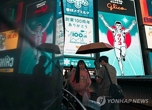 관광명소인 오사카의 일명 ‘글리코’ 간판 앞. EPA 연합뉴스 자료사진