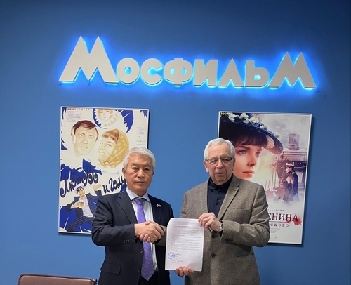 문종금(왼쪽) 한러친선협회 이사장과 알렉산드르 리트비노프 러시아 모스필름 프로듀서가 지난 16일(현지시간) 모스크바 모스필름 사옥에서 독립운동가 최재형의 일대기를 다루는 영화 ‘표트르 최’ 제작 지원 협약 문서에 서명하고 악수하고 있다. 연합뉴스