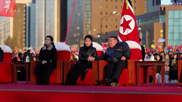 김정은 북한 국무위원장이 부인 리설주, 딸 주애와 함께 지난 16일 평양 화성지구 4단계 1만 세대 살림집 준공식 경축공연을 관람하던 중 주애가 김 위원장이 펼친 손을 두 손으로 어루만지고 있다. [조선중앙TV 화면]