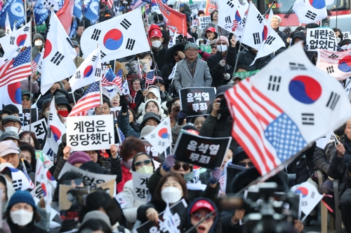 내란 우두머리 혐의로 기소된 윤석열 전 대통령의 1심 선고가 열리는 19일 서울 서초구 서울중앙지방법원 인근에서 지지자들이 손팻말을 들고 있다. [연합뉴스]