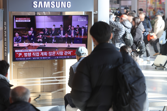 12·3 비상계엄과 관련해 내란 우두머리 혐의로 기소된 윤석열 전 대통령에 대한 1심 선고가 열린 19일 서울역에서 시민들이 관련 뉴스를 보고 있다. [연합뉴스]
