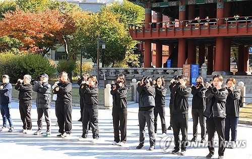세계 여성 폭력 추방 주간을 맞아 2025년 11월 14일 서울 종각 앞에서 한국여성의전화 관계자들이 여성 살해 규탄 퍼포먼스 ‘114번의 신고 114번의 실패’를 행사 시작 전 준비하고 있다.   [연합뉴스]
