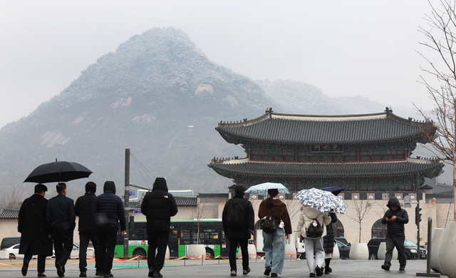진눈깨비가 내리는 6일 서울 광화문광장에서 시민들이 걷고 있다. 연합뉴스