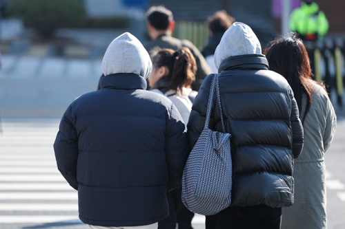 아침 기온이 큰 폭으로 떨어지며 전국 대부분 지역이 영하권에 든 7일 서울 종로구 광화문광장에서 외투와 모자를 착용한 시민들이 길을 건너고 있다. [연합뉴스]