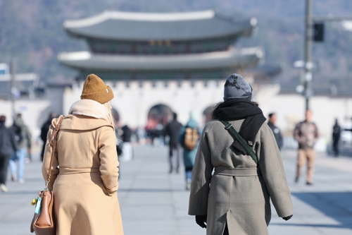 아침 기온이 큰 폭으로 떨어지며 전국 대부분 지역이 영하권에 든 7일 서울 종로구 광화문광장에서 외투와 모자를 착용한 관광객들이 이동하고 있다. [연합뉴스]