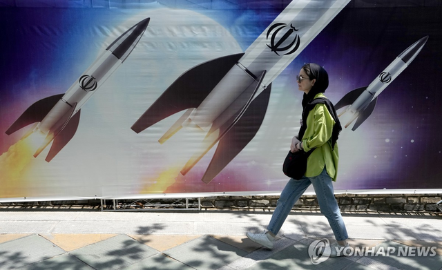 테헤란 도심에 설치된 미사일 그림 앞을 지나는 여성 [AP 연합뉴스 자료사진]