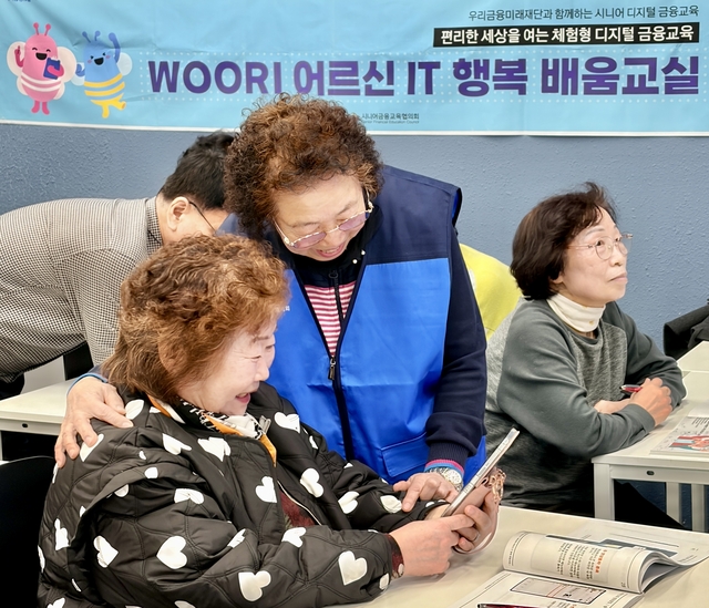 ‘우리 어르신 IT 행복 배움교실’ 에서 전년도 우수 수강생(강옥연님)이 보조강사로 활동하며 다른 수강생들을 돕고 있다. [우리금융그룹 제공]