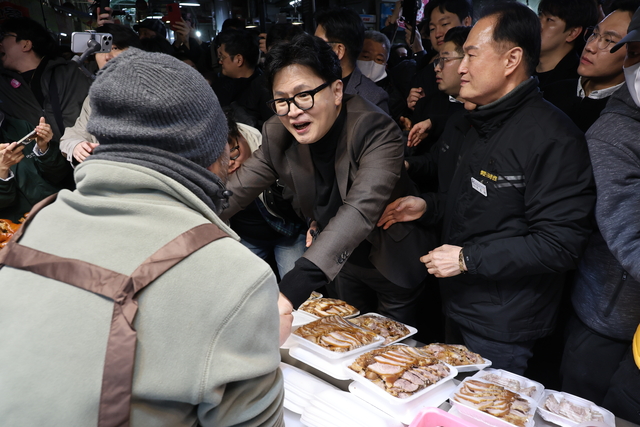한동훈 전 국민의힘 대표가 7일 부산 북구 구포시장의 한 족발집을 찾아 상인과 인사하고 있다. [연합뉴스]