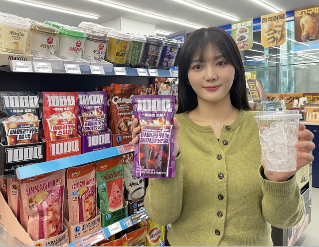 GS25 매장에서 모델이 1000원 아이스커피와 얼음컵을 들고 포즈를 취하고 있다. [GS25 제공]