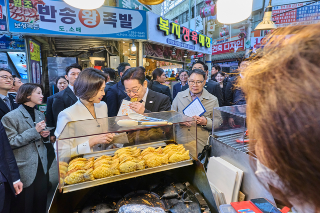 이재명 대통령과 김혜경 여사가 15일 경남 창원시 성산구 반송시장을 찾아 붕어빵을 맛보고 있다. [연합뉴스]