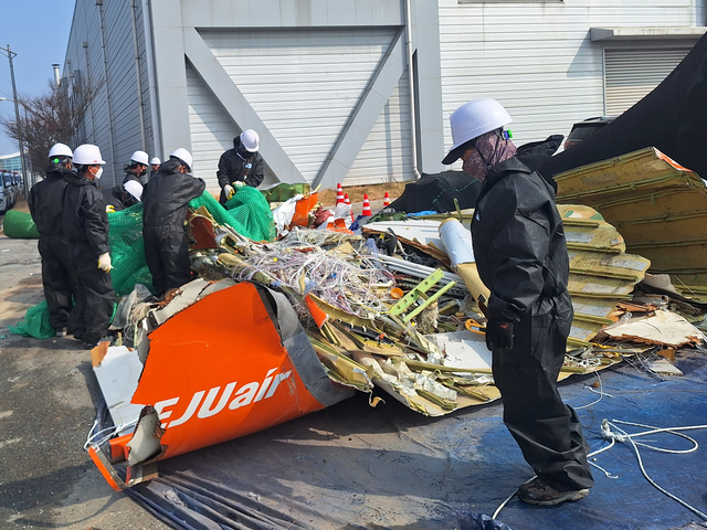 12일 국토교통부와 항공철도사고조사위원회, 전남경찰청 과학수사대 관계자들이 무안국제공항 공항소방대 뒤편에 보관된 여객기 잔해를 조사하고 있다.  [12·29 무안공항 제주항공 여객기 참사 유가족협의회 제공