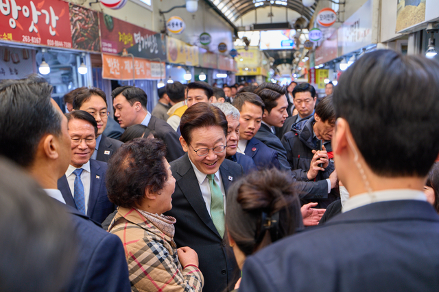 이재명 대통령이 13일 충북 청주시 서원구 사창시장을 찾아 상인 및 시민들과 인사를 하고 있다. [연합뉴스]