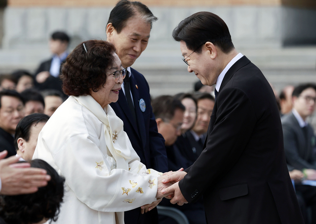 이재명 대통령이 15일 경남 창원시 마산회원구 국립 3·15 민주 묘지에서 열린 제66주년 3·15의거 기념식에서 기념사를 마친 뒤 오무선 유족회장의 손을 잡고 있다.  [청와대통신사진기자단]
