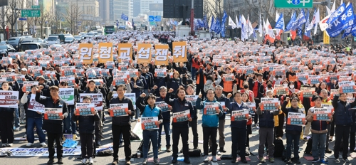 ‘노란봉투법’(노동조합 및 노동관계조정법 2·3조 개정 법률) 시행 첫날인 지난달 10일 서울 세종로에서 열린 민주노총 투쟁 선포대회에서 양경수 위원장을 비롯한 민주노총 조합원들이 손팻말을 들고 구호를 외치고 있다. [연합뉴스]