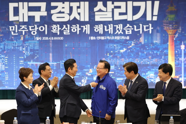 정청래 더불어민주당 대표가 8일 대구 북구 인터불고 엑스코 호텔에서 열린 더불어민주당 현장 최고위원회의에서 대구시장 후보인 김부겸 전 국무총리에게 당 점퍼를 입혀주고 있다. [연합뉴스]
