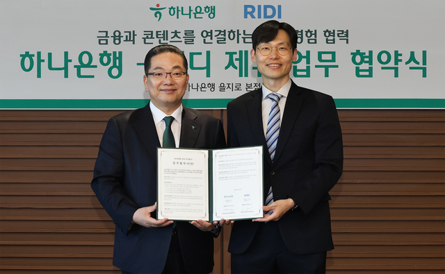 이호성(왼쪽) 하나은행장이 배기식 리디 대표이사와 지난 10일 오후 서울 을지로 본점에서 국내 대표 콘텐츠 플랫폼 기업 리디(RIDI) 주식회사와 함께 금융·콘텐츠 결합을 통한 새로운 고객 경험 제공을 위해 업무협약을 체결한 뒤 기념촬영을 하고 있다. [하나은행 제공]