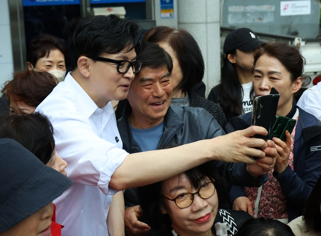 한동훈 전 국민의힘 당대표가 14일 오후 부산 북구 만덕2동 행정복지센터를 찾아 전입신고를 마친 뒤 주민들과 사진을 찍고 있다.[연합뉴스 사진]