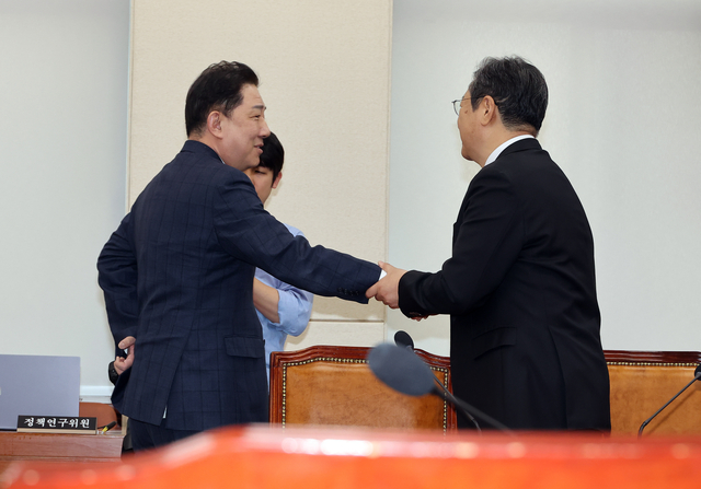 뇌물수수 등 혐의를 받는 김병기 무소속 의원이 14일 국회에서 열린 국방위원회 전체 회의에 출석해 황희 더불어민주당 의원과 인사를 나누고 있다. [연합뉴스]