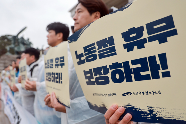 지난 3월 18일 국회 본청 앞 계단에서 전국공무원노동조합과 대한민국공무원노동조합총연맹이 연 공무원 노동절 휴무 쟁취 기자회견에서 참석자들이 손팻말을 들고 있다.   [연합뉴스]