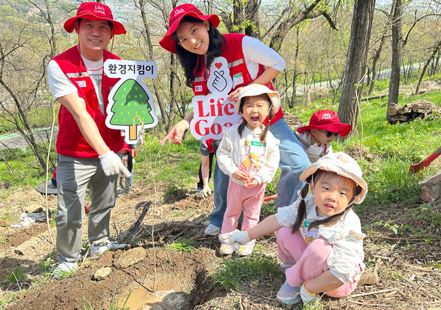 LG전자 임직원들이 18일 서울 마포구 노을공원을 찾아 자녀들과 함께 나무심기 활동에 참가하고 있다. LG전자 제공