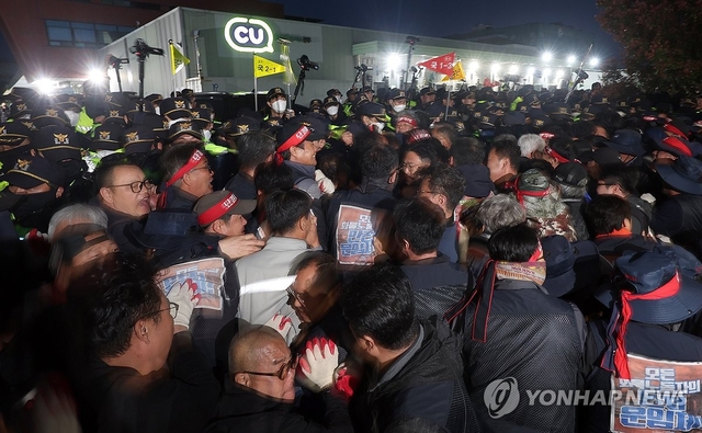 경남 진주시 정촌면 BGF로지스 진주센터에서 20일 오후 화물연대 관계자가 센터 입구로 진입하려는 과정에서 경찰과 대치하고 있다. [연합뉴스]