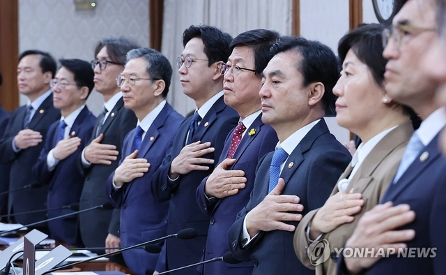 최교진(오른쪽 네번째) 교육부장관이 지난 29일 서울 종로구 정부서울청사에서 열린 임시국무회의 겸 비상경제본부회의에서 국기에 경례하고 있다. [연합뉴스]