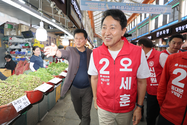 오세훈 국민의힘 서울시장 후보가 9일 서울 동대문구 경동시장을 찾아 상인 및 시민들과 인사를 나누고 있다. 연합뉴스