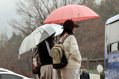 봄비가 내린 18일 광주 동구 조선대학교에서 학생들이 우산을 쓰고 서 있다. [광주=연합뉴스]