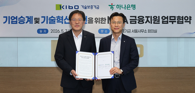 서유석(오른쪽) 하나은행 기업그룹 부행장이 이상창 기술보증기금 이사와 지난 7일 서울 영등포구 기술보증기금 서울사무소에서 협약서를 들고 기념촬영을 하고 있다. [하나은행 제공]