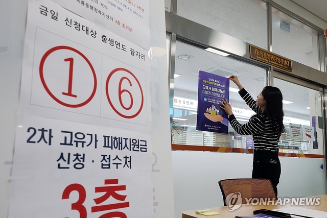 18일부터 시작되는 ‘고유가 피해지원금’  2차 지급을 나흘 앞둔 14일 충남 공주시 옥룡동 행정복지센터에서 한 직원이 신청자들을 위한 안내문을 붙이고 있다. [연합뉴스]