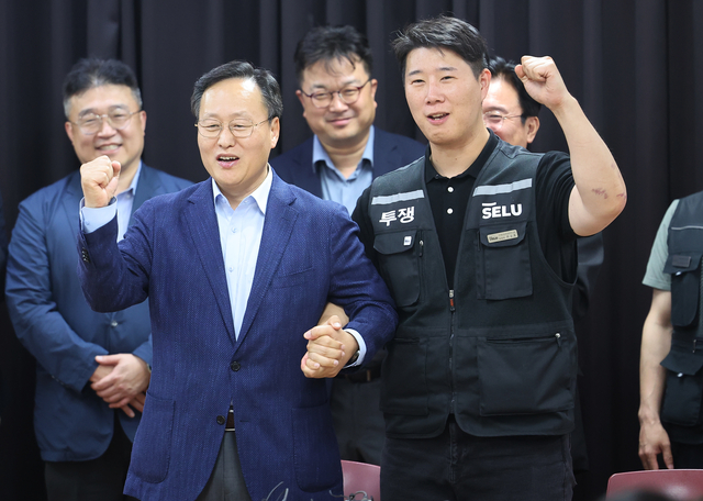 경기도 수원시 장안구 경기고용노동청에서 20일 열린 삼성전자 임금협상을 마친 후 여명구 삼성전자 DS(디바이스솔루션·반도체 사업 담당) 피플팀장과 최승호 삼성그룹 초기업노동조합 삼성전자지부 위원장이 잠정 합의안에 서명한 후 파이팅을 외치고 있다. [연합뉴스]
