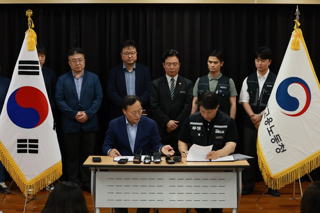 지난 20일 경기도 수원시 장안구 경기고용노동청에서 열린 삼성전자 임금협상을 마친 후 여명구 삼성전자 DS 피플팀장과 최승호 삼성그룹 초기업노동조합 삼성전자지부 위원장이 잠정 합의안에 서명하고 있다.  [사진공동취재단]