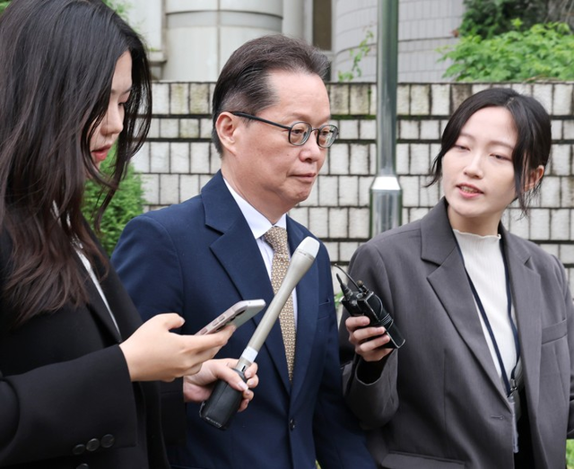 12·3 비상계엄과 관련해 내란선전 혐의를 받는 이은우 전 한국정책방송원(KTV) 원장(가운데)이 21일 서울 서초구 서울중앙지법에서 열린 구속 전 피의자 심문(영장실질심사)을 마치고 나오며 취재진의 질문을 받고 있다. [연합뉴스]