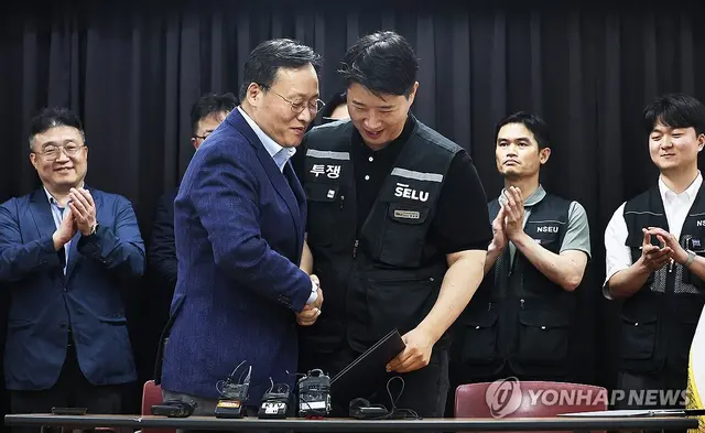여명구 삼성전자 DS(디바이스솔루션·반도체 사업 담당) 피플팀장과 최승호 삼성그룹 초기업노동조합 삼성전자지부 위원장이 잠정 합의안에 서명한 후 손을 맞잡는 모습. 연합뉴스