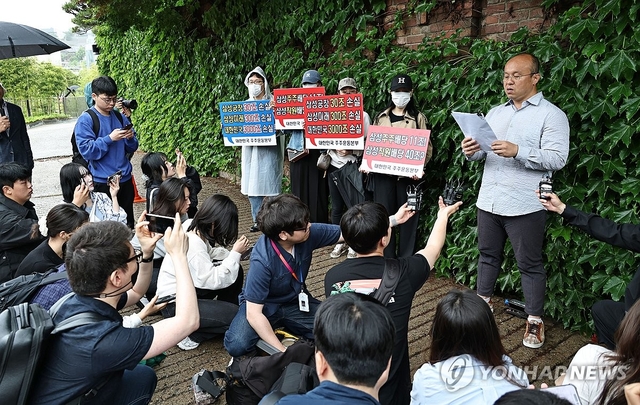 21일 서울 용산구 이재용 삼성전자 회장 자택 앞에서 열린 삼성전자 주주 총결집 집회에서 삼성전자 주주단체인 '대한민국 주주운동본부' 관계자들이 손팻말을 들고 있다. 이날 주주운동본부는 삼성전자 노사의 임금협상 잠정 합의안을 위법으로 규정하며 법적 대응을 예고했다. 연합뉴스

